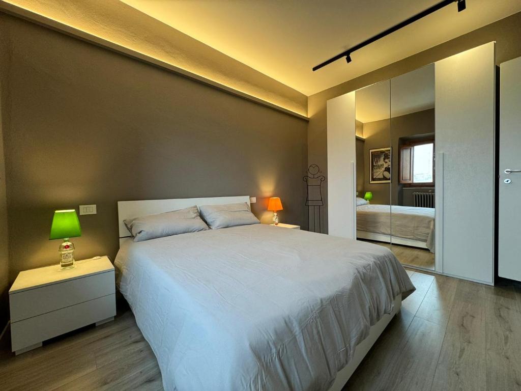 1 dormitorio con 1 cama blanca grande y espejo en Casa i Portici en Arezzo