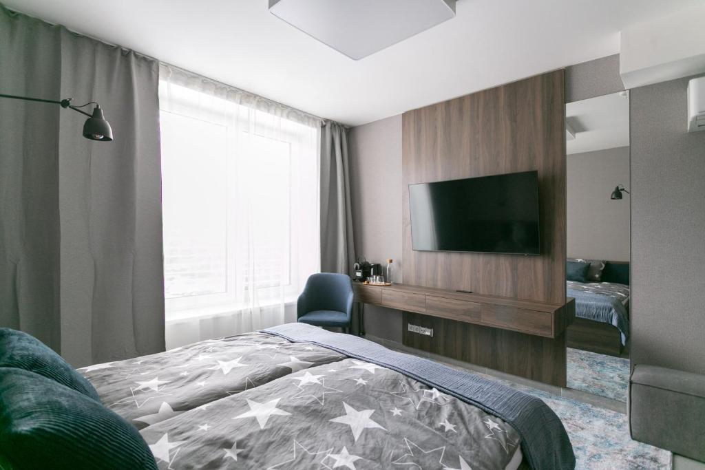 a bedroom with a bed and a flat screen tv at LUONG Europe Apartments in Prague