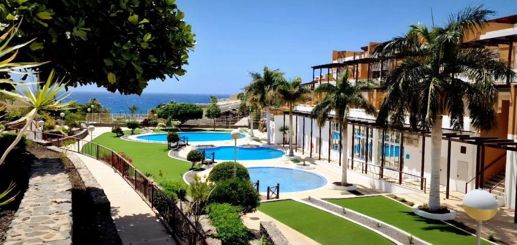een uitzicht op een resort met 2 zwembaden en palmbomen bij Casa de la Kosa in San Miguel de Abona