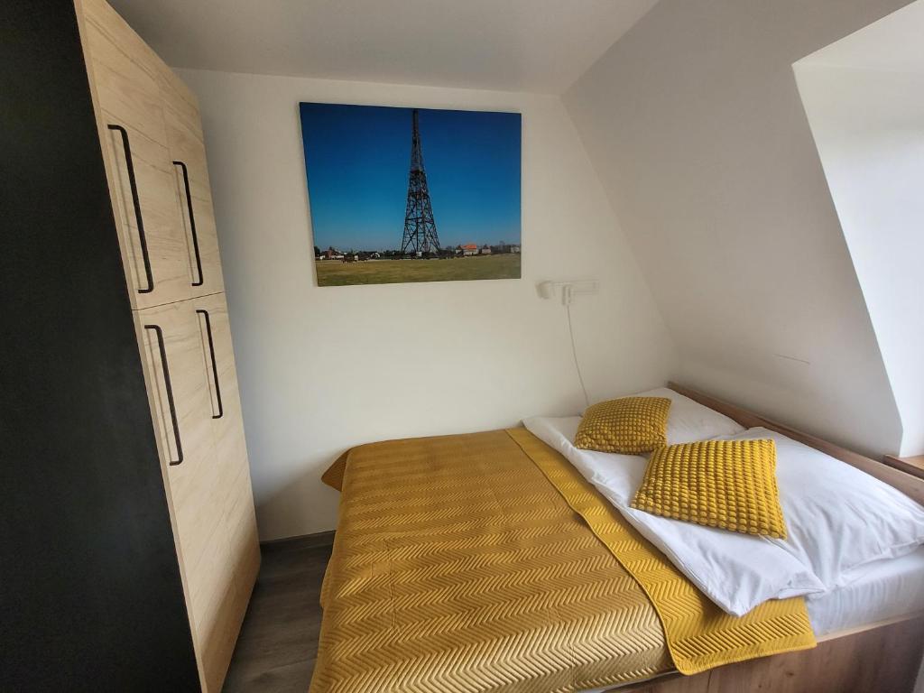 een kleine slaapkamer met een bed met gele kussens bij Apartament Pod Radiostacją -Gliwice Tarnogórska, parking in Gliwice