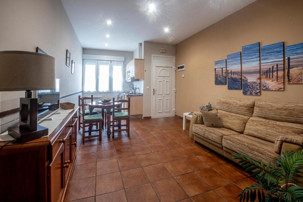 a living room with a couch and a table at Apartamentos turísticos La Flor in Muros de Nalón