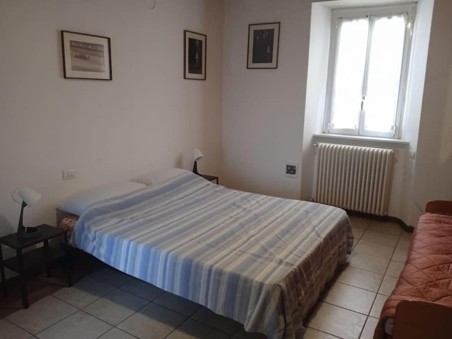 ein Schlafzimmer mit einem Bett, einem Fenster und einem Sofa in der Unterkunft Appartamento Prima Torre in Primaluna