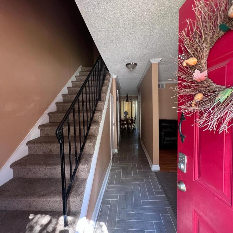 a staircase in a house with a red door at #2BR Cozy Villa - Mins to Historic STM Amusement Park! in Stone Mountain