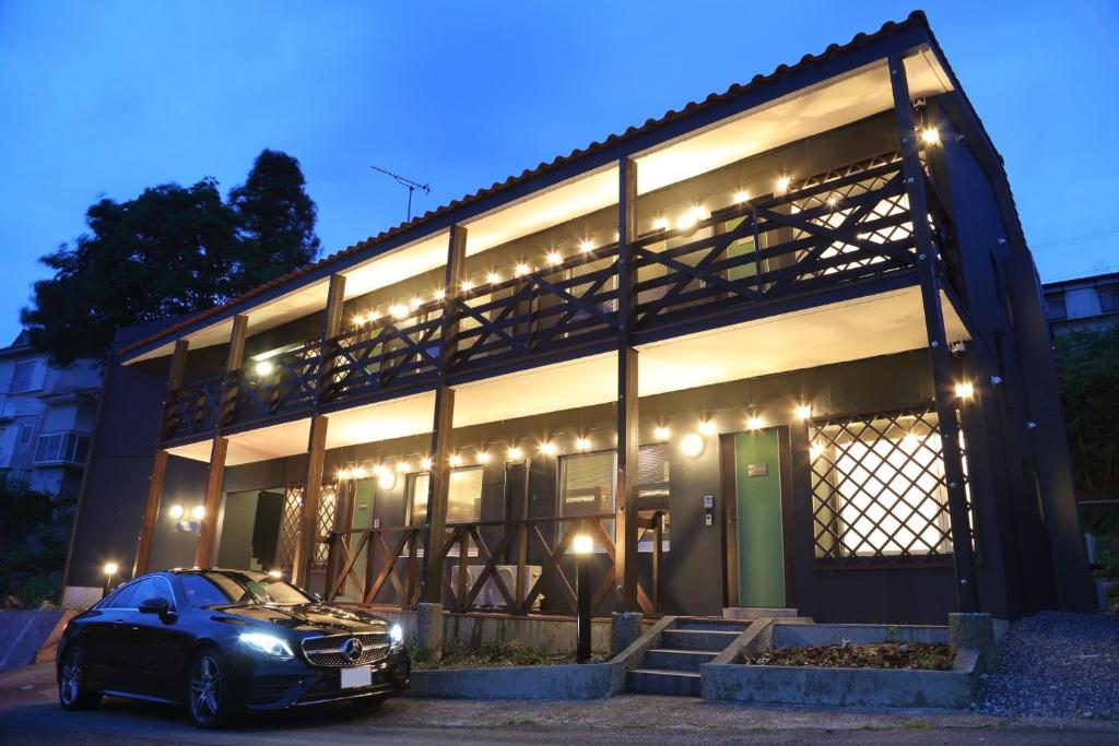 une voiture garée devant un bâtiment la nuit dans l'établissement Time Traveler Izu-Shuzenji Onsen - Vacation STAY 32421v, à Izu