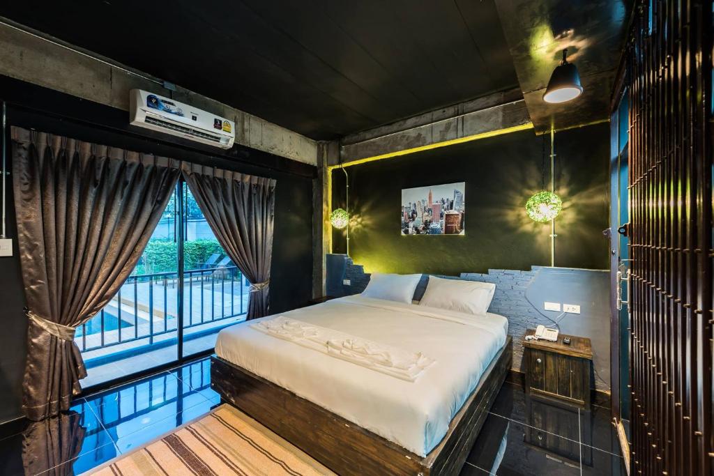 a bedroom with a bed and a large window at Nine blue residence in Nong Prue