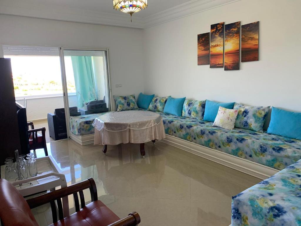 uma sala de estar com um sofá com almofadas azuis em ASILAH MARINA GOLF em Asilah