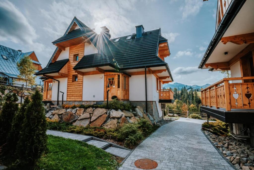 uma casa de madeira com um telhado preto em Mountain Base - Dom Hrabiego em Zakopane
