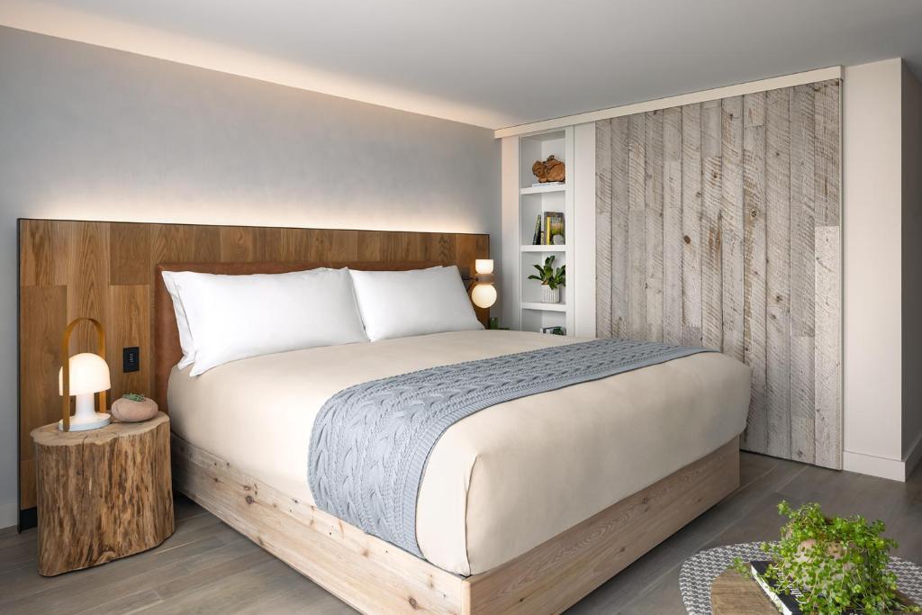 a bedroom with a large bed with a wooden headboard at 1 Hotel Toronto in Toronto