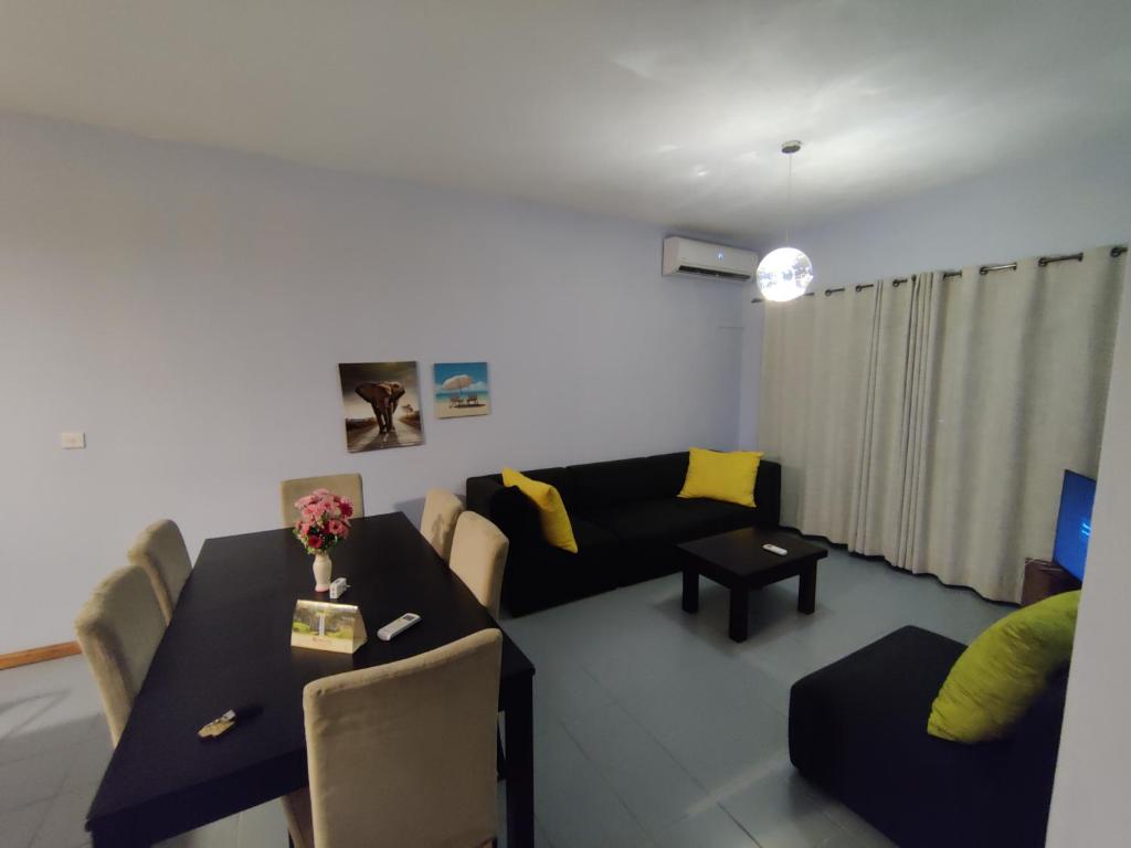 a living room with a couch and a table at Ashiana OceanSide Apartment in Flic-en-Flac