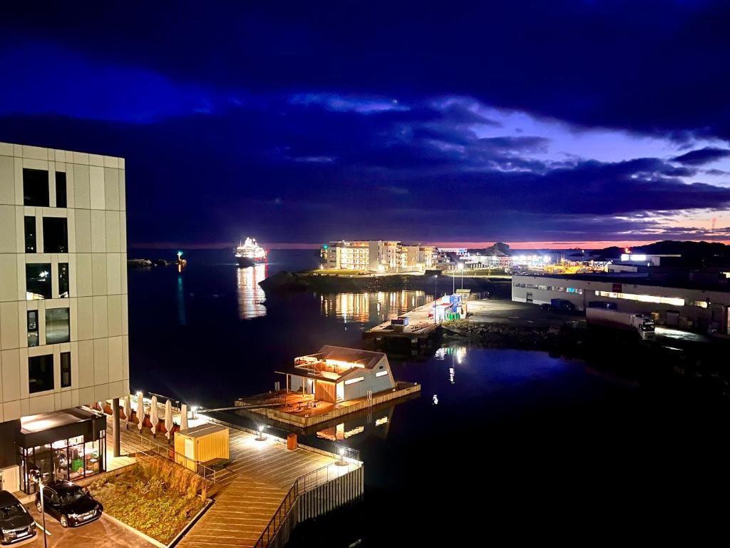 een uitzicht op een stad in de nacht met een jachthaven bij Luxury penthouse apt with amazing views in Svolvær