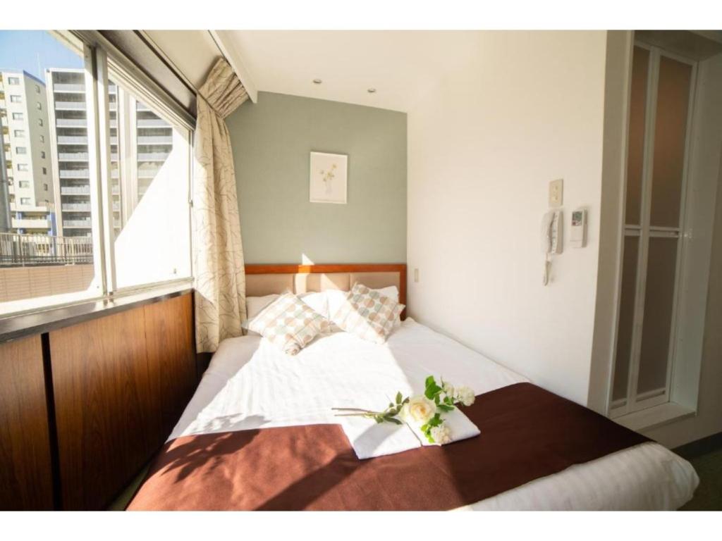 1 dormitorio con 1 cama grande y ventana en Tabata Oji Hotel - Vacation STAY 89839v, en Tokio