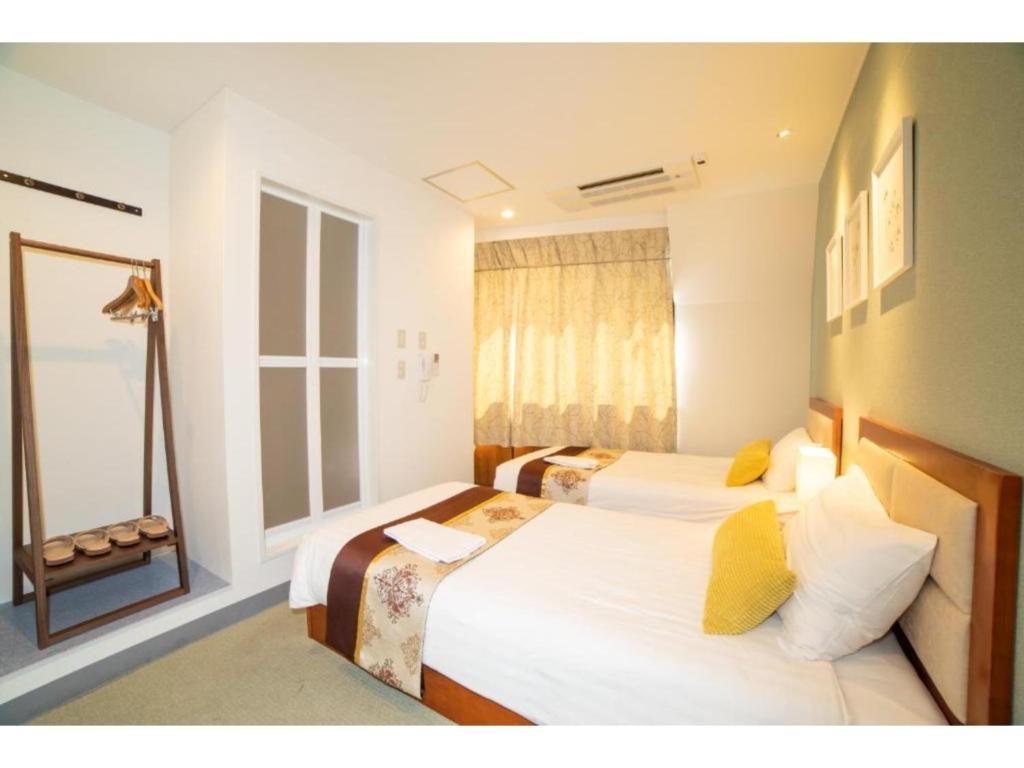 a bedroom with two beds and a window at Tabata Oji Hotel - Vacation STAY 89843v in Tokyo