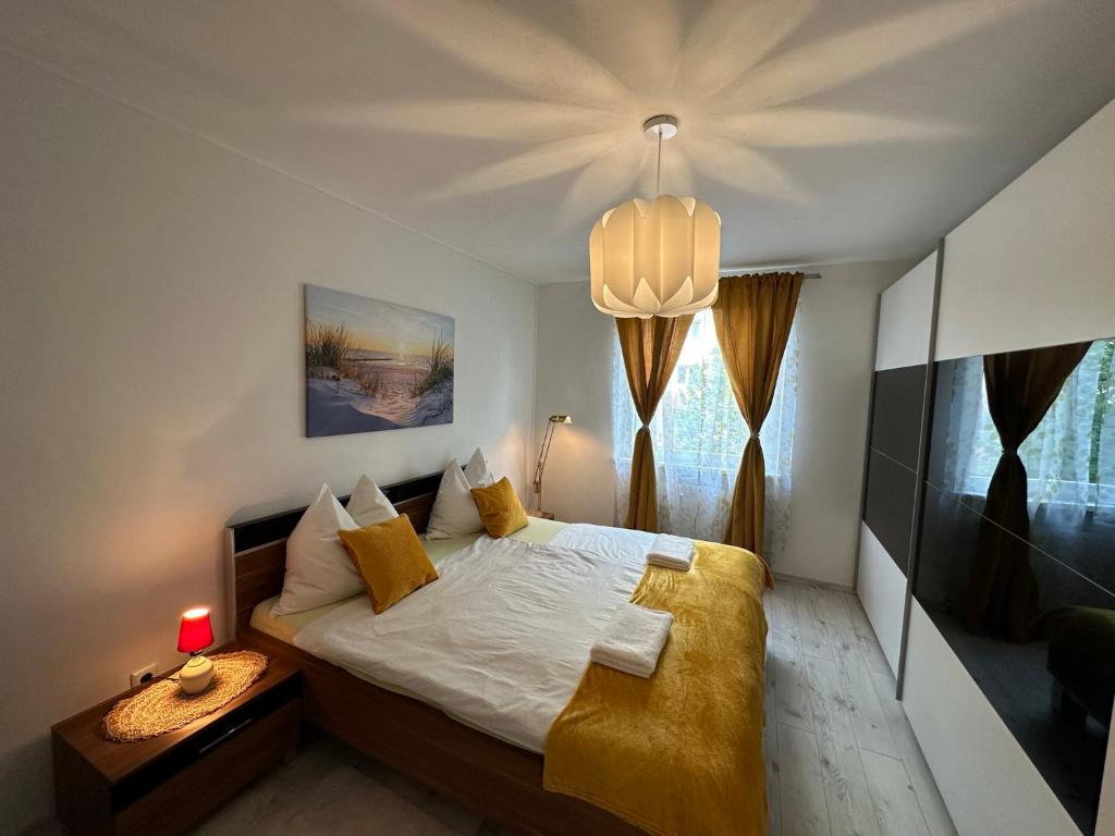 a bedroom with a large bed and a chandelier at Central Station Comfort, Your Cozy Home with free Parking in Salzburg