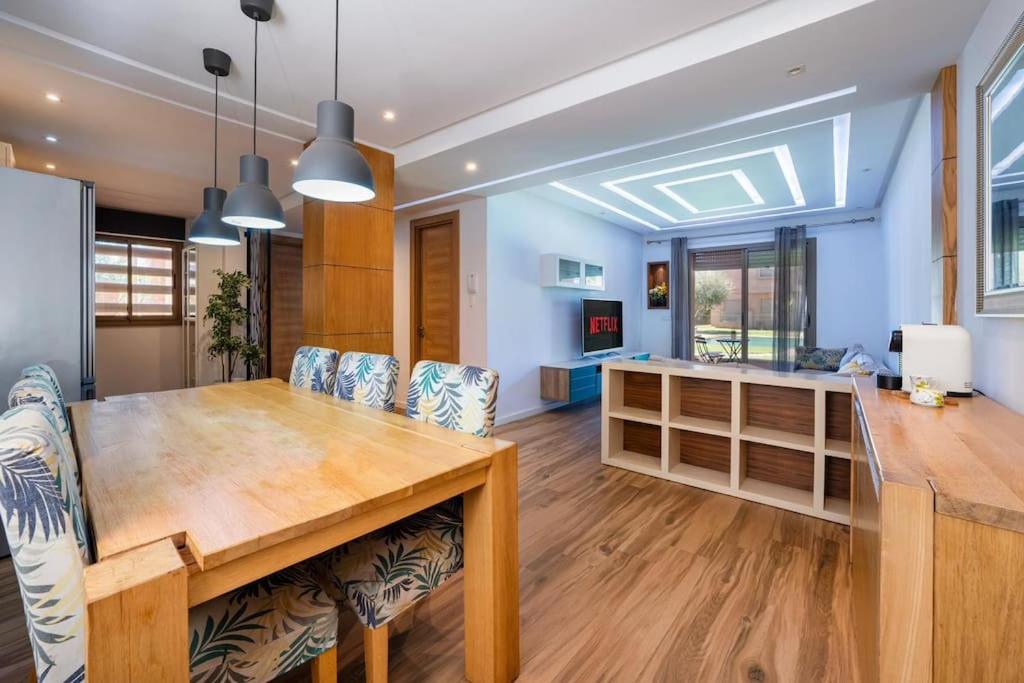 Il comprend une cuisine et une salle à manger avec une table et des chaises en bois. dans l'établissement L’Unique appartement Z. Coralia, à Marrakech
