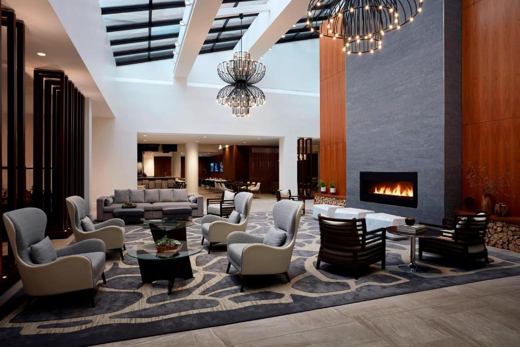 un vestíbulo con sillas y una chimenea en un hotel en Long Island Marriott Hotel, en Uniondale