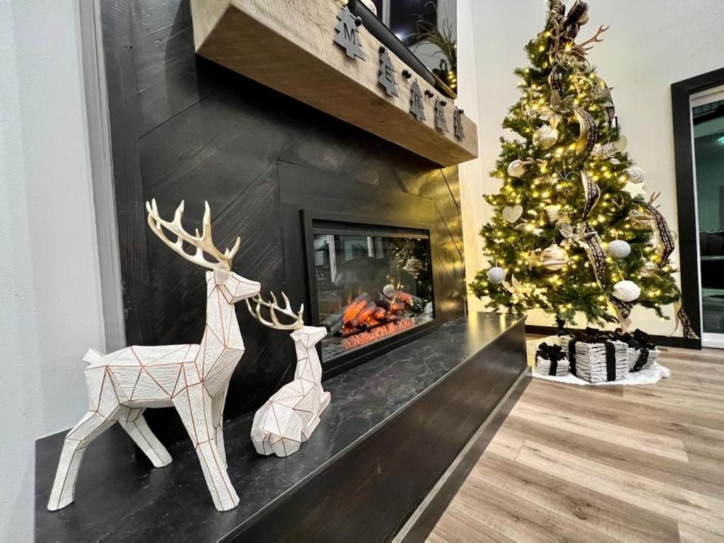 ein Kamin mit einem Weihnachtsbaum und zwei Rentierdekorationen in der Unterkunft Luxury 7BED Lakefront Lodge 4- FREE Resort Amenities-Pool/Hot Tubs - PERFECT FOR LARGE FAMILY in Kimberling City
