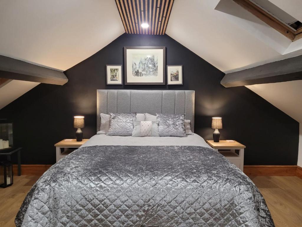 1 dormitorio con 1 cama grande y paredes negras en Snowdon view, steam railway & Portmeirion nearby en Minffordd