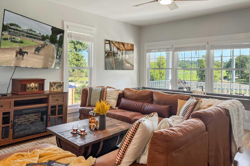 uma sala de estar com um sofá e uma televisão em Shelbyville Farmhouse with Hot Tub, Fire Pit and Grill em Shelbyville