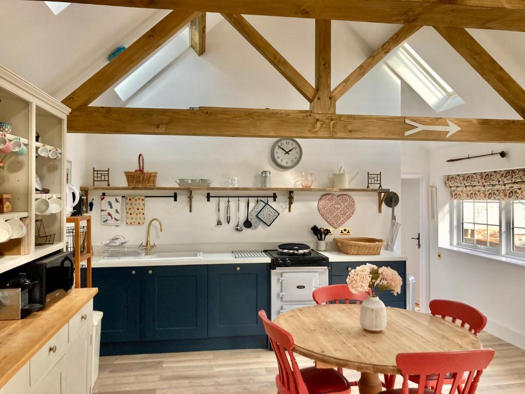eine Küche mit blauen Schränken und einem Holztisch in der Unterkunft The Old Workshop, Wadhurst in Wadhurst