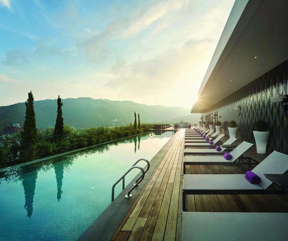 a hotel swimming pool with a view of the mountains at G Hotel Kelawai in George Town
