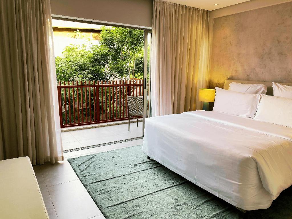 um quarto com uma grande cama branca e uma varanda em Flat Île de Pipa Varanda - By Almare em Pipa