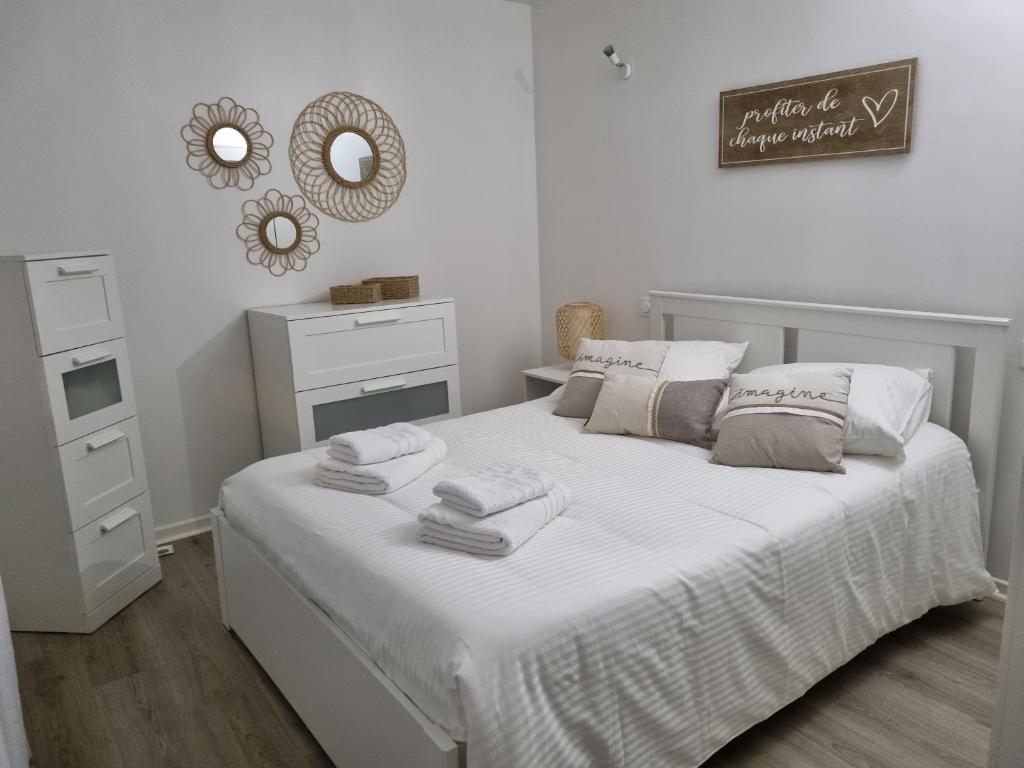 une chambre avec un lit blanc avec des serviettes dessus dans l'établissement Maison ville dans une voie privée, à Saint-Ouen