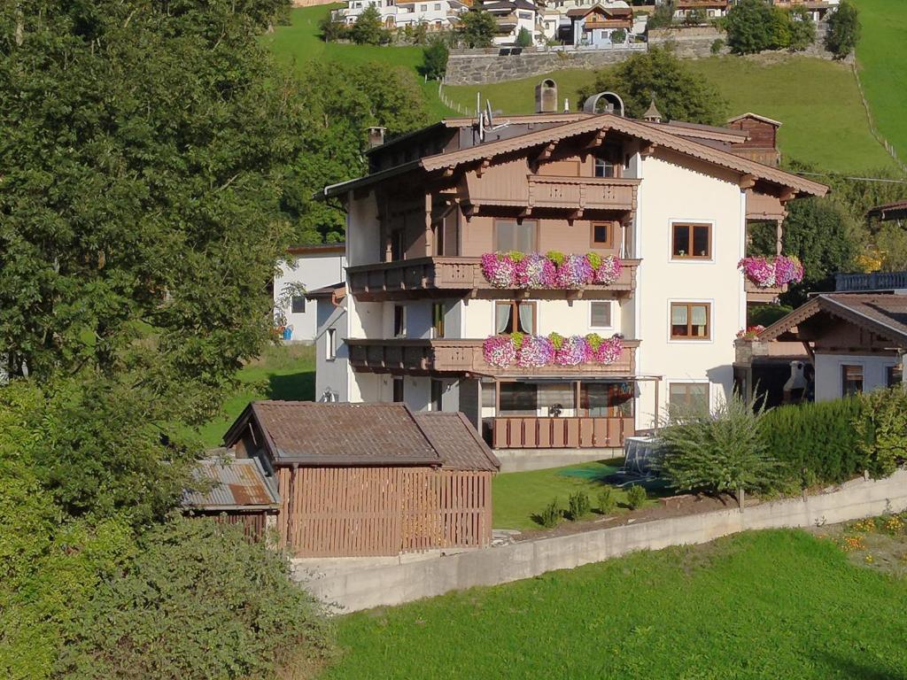 a house with a balcony with flowers on it at Appart Mona in Ramsau im Zillertal