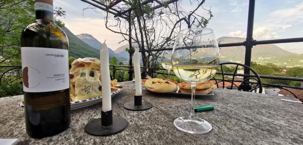 uma garrafa de vinho e um copo sobre uma mesa em AL CASTANEDO em Domodossola