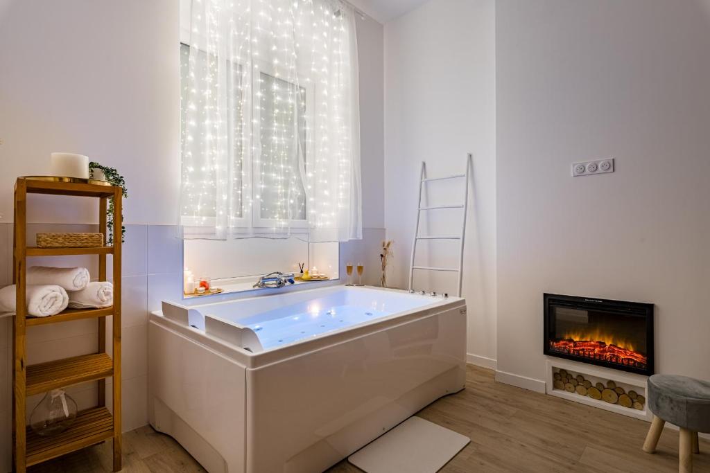 a bath tub in a bathroom with a fireplace at Suite Évasion Céleste à Saint-Étienne in Saint-Étienne
