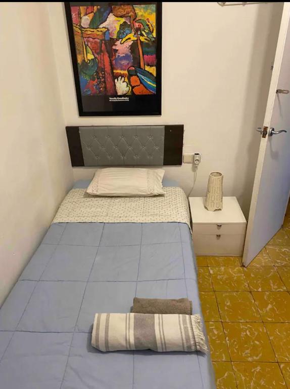 um pequeno quarto com uma cama e um quadro na parede em Habitación céntrica em Barcelona