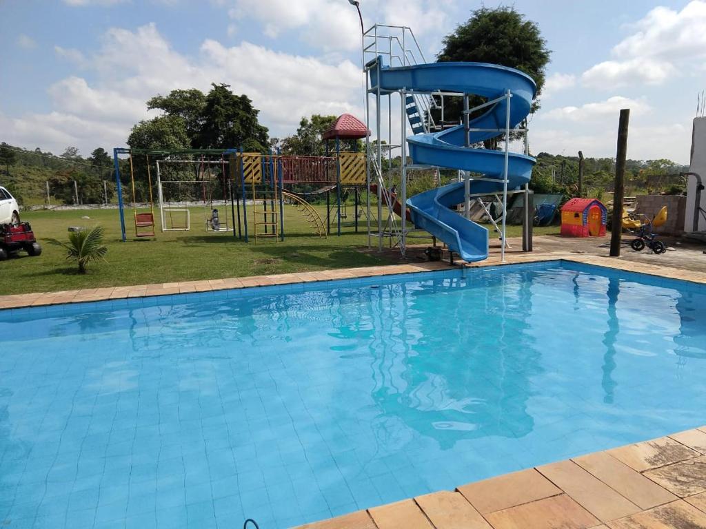 ein großer Pool mit blauer Rutsche in einem Park in der Unterkunft Chácara 4 Ases J R in Cotia