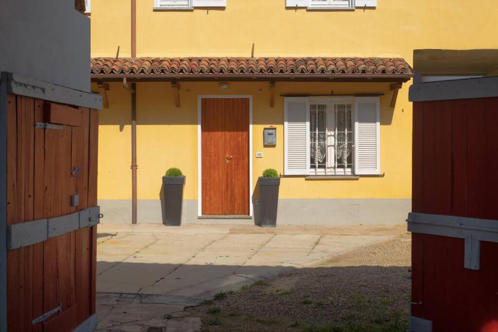 una casa amarilla con dos puertas y una ventana en Maria's Bed - Intero alloggio accogliente, en Dorno