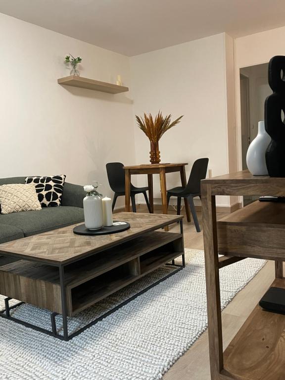 un salon avec un canapé et une table dans l'établissement MC Suite CMZ Métropolis PlaceDucale, à Charleville-Mézières