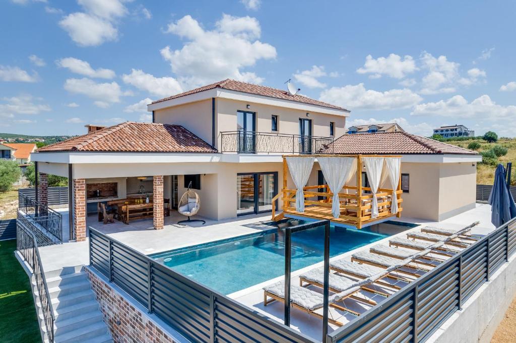 een villa met een zwembad en een huis bij Villa A Lauda in Vrana