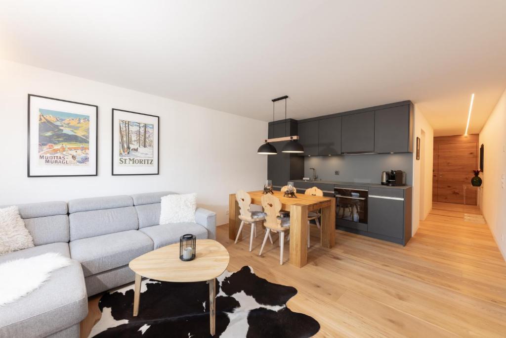 ein Wohnzimmer mit einem Sofa und einem Tisch in der Unterkunft New! Cozy, central apartment with a stunning view in St. Moritz