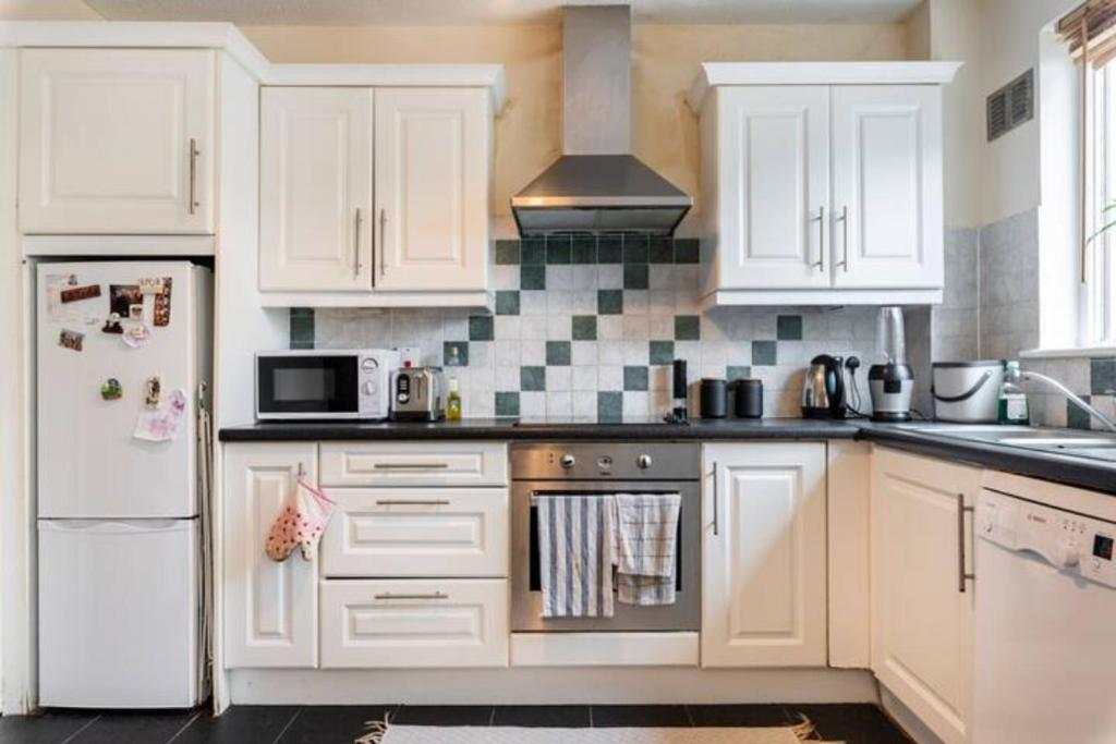 cocina con armarios blancos y nevera blanca en Twin bed in a quiet area, en Dublín
