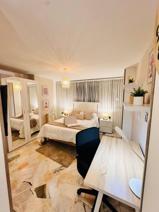 a bedroom with a bed and a desk in it at hermoso aparta estudio nórdico in Cali