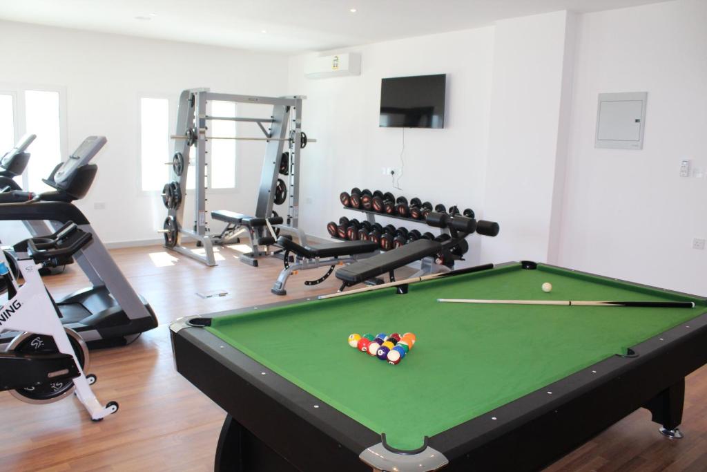 a fitness room with a pool table and exercise equipment at Duqm Express Hotel in Duqm