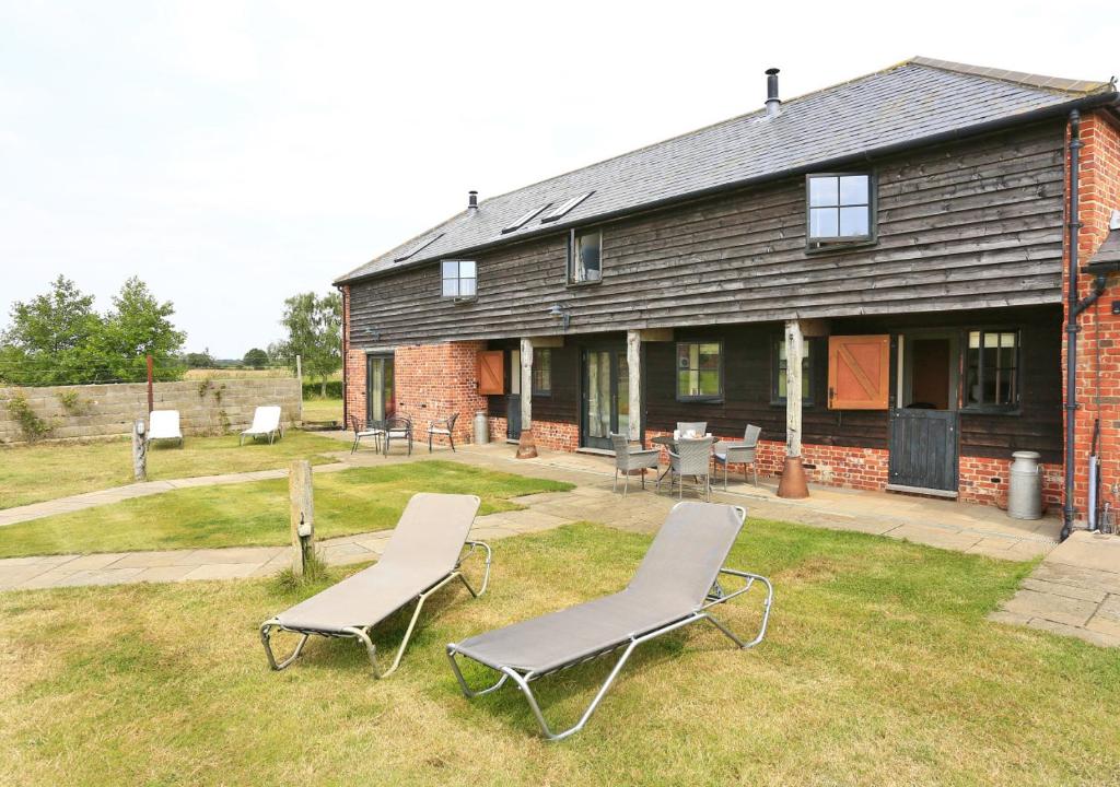 una casa con dos sillas de jardín delante en Harrow Cottage, en Yoxford