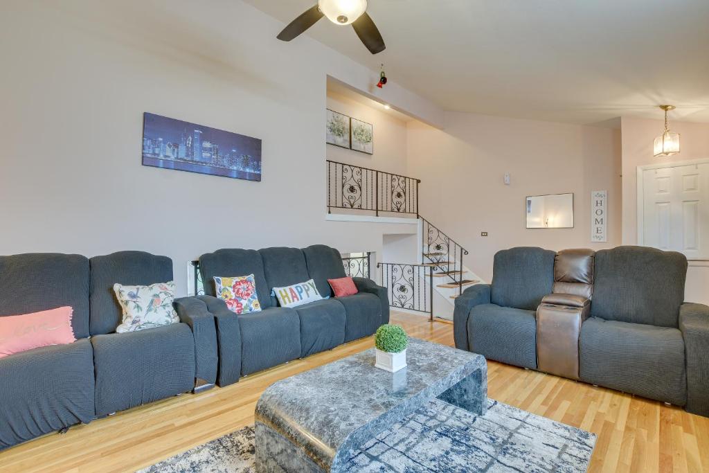 una sala de estar con 2 sofás azules y una mesa. en Des Plaines Family Getaway with Private Backyard, en Des Plaines