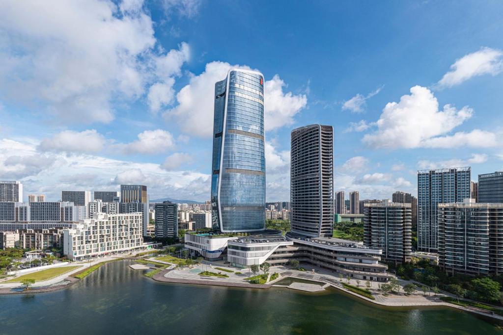 een stad met een hoog gebouw naast een waterlichaam bij Zhuhai Marriott Hotel Jinwan in Zhuhai