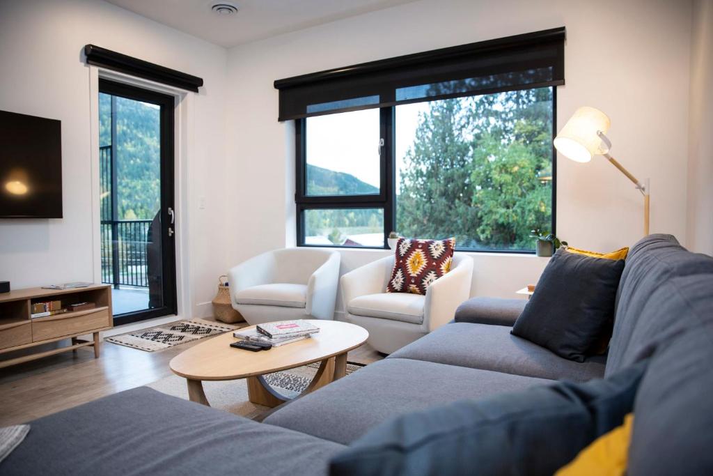 a living room with a couch and a table at Le Refuge - Revelstoke Condo with Hot Tub in Revelstoke