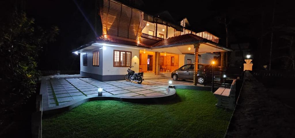 a house with a car parked in front of it at night at Thekkumbath Sea Breeze Pool villa in Kannur