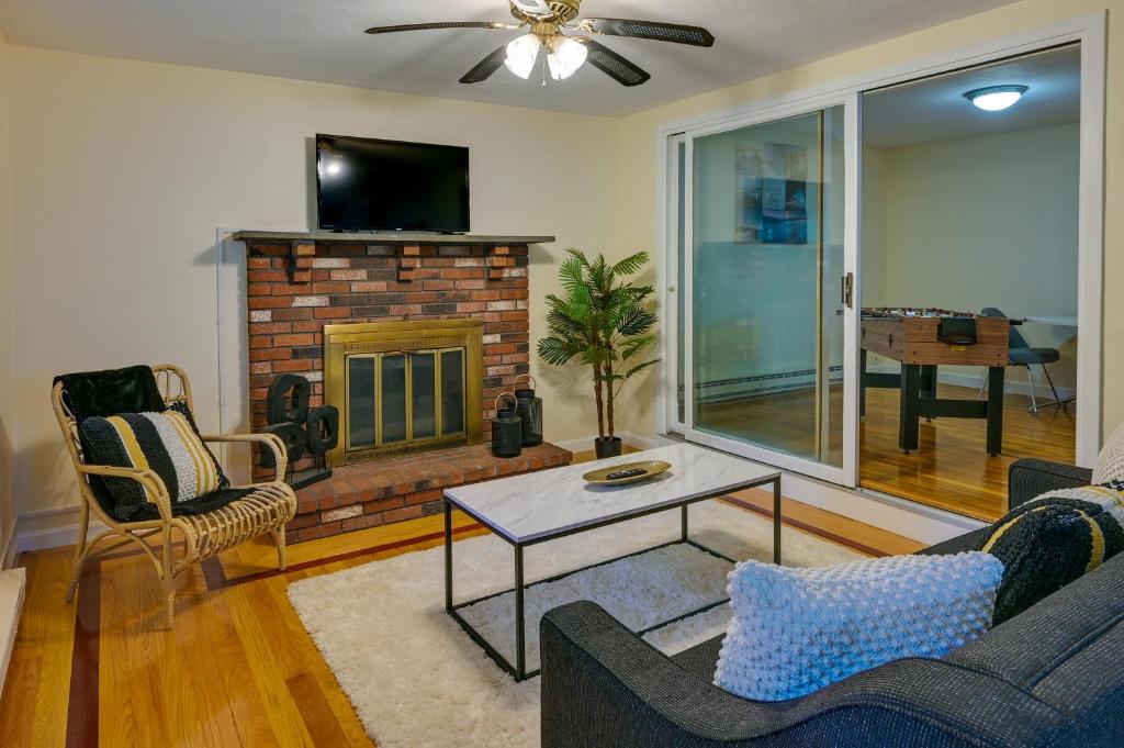 a living room with a fireplace and a tv at Boston Duplex with Foosball Table 11 Mi to Downtown in Boston