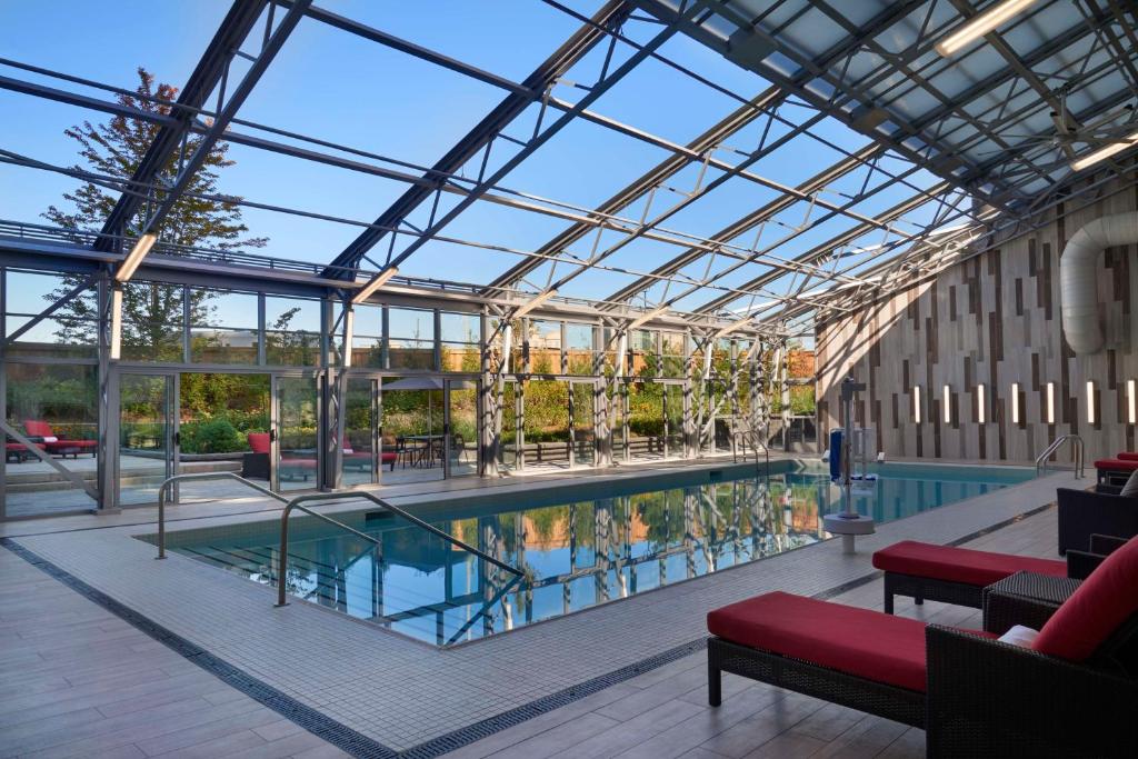 a swimming pool in a building with a glass ceiling at Hilton Toronto Airport Hotel & Suites in Mississauga