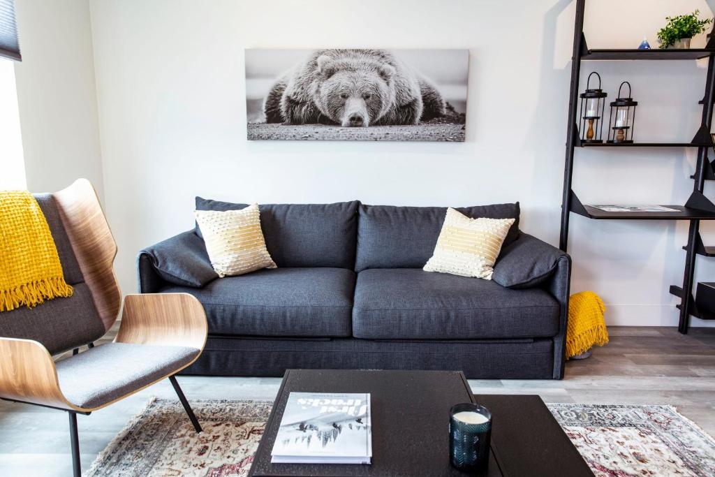 a living room with a couch and a bear picture on the wall at The Bear Lair - 2 Bedroom with Hot Tub in Revelstoke