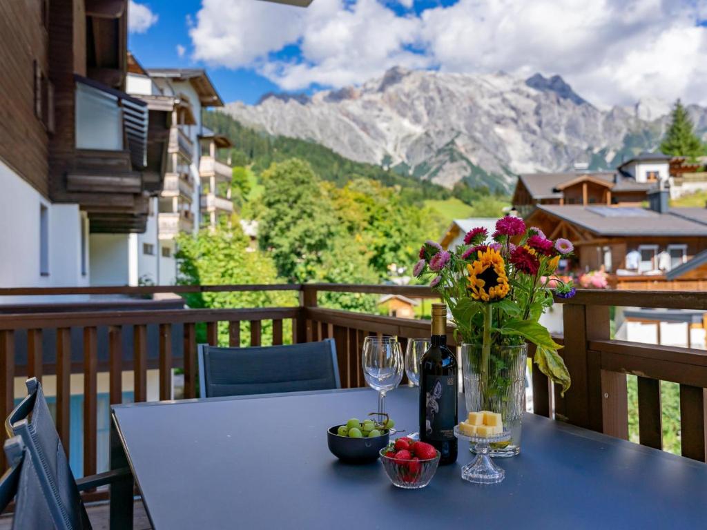 a table with a vase of flowers on a balcony at Emma Top 2 in Dienten am Hochkönig