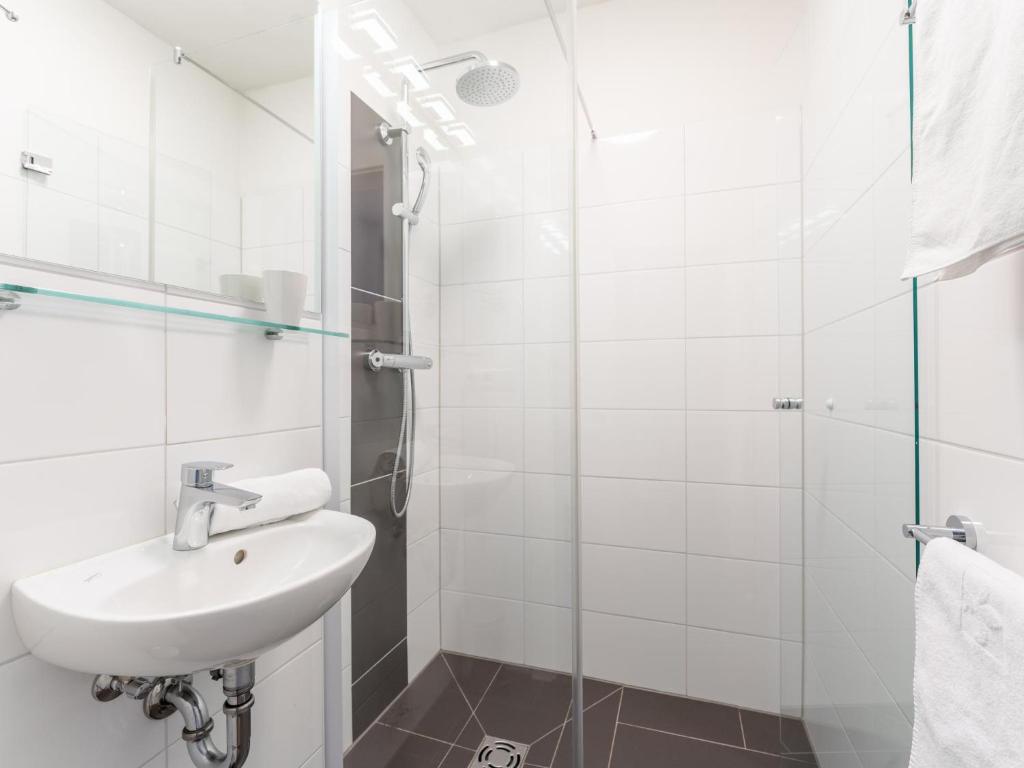 a white bathroom with a sink and a shower at Emma Top 2 in Dienten am Hochkönig