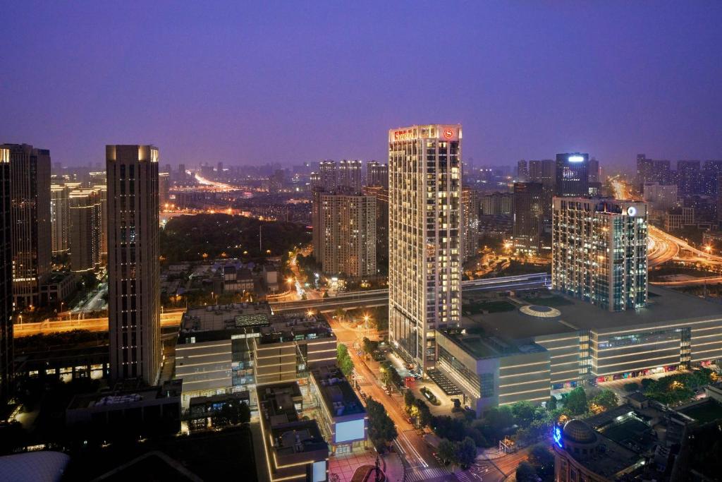 un perfil urbano con edificios altos por la noche en Sheraton Grand Wuhan Hankou Hotel - Let's take a look at the moment of Wuhan en Wuhan