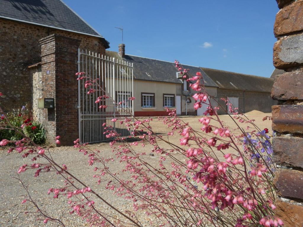 einen Zaun mit rosa Blumen vor einem Haus in der Unterkunft Gîte Challet, 5 pièces, 6 personnes - FR-1-581-105 